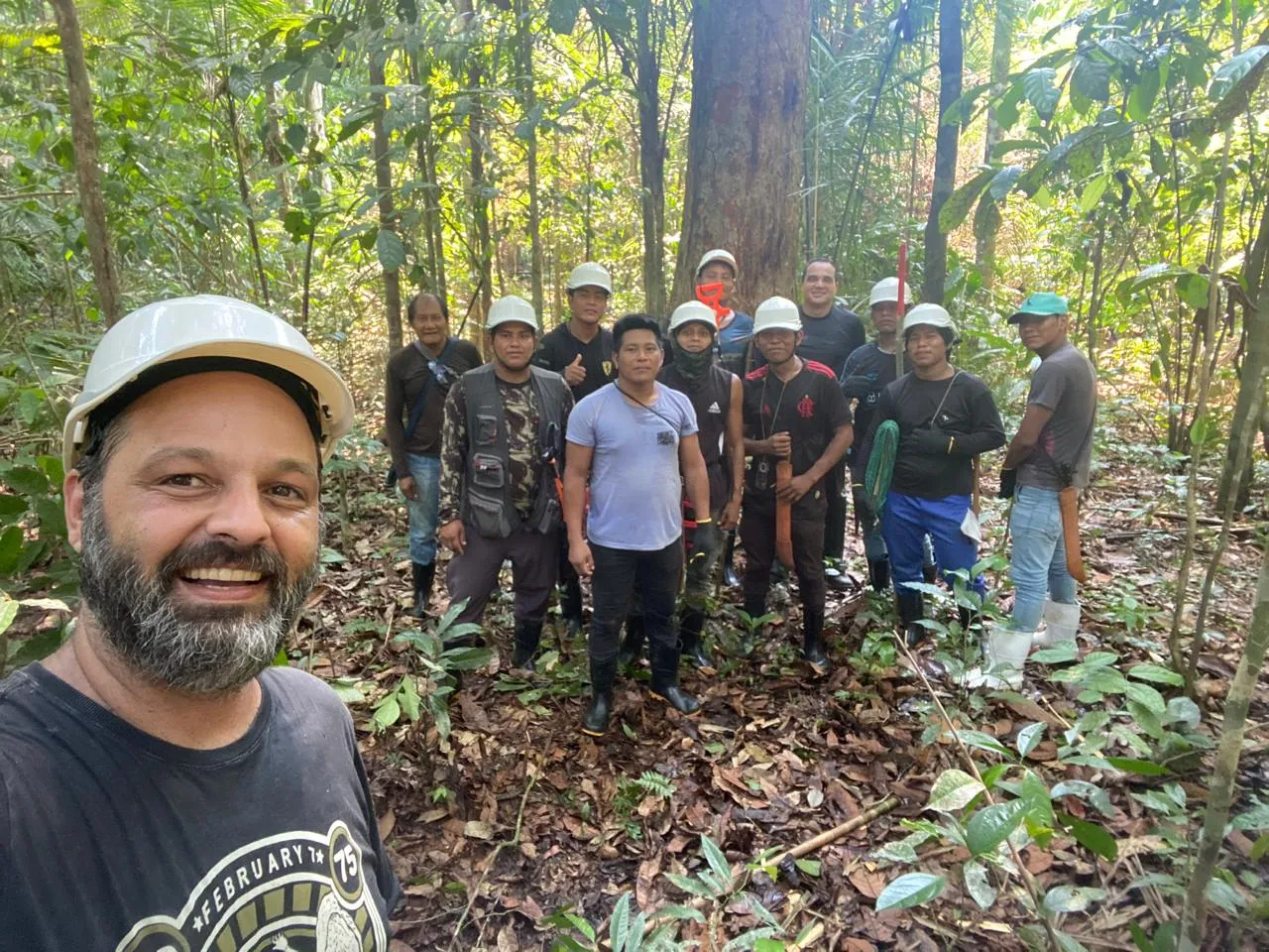 Time misto de inventário florestal posa para foto sob a floresta amazônica preservada na TI Baú